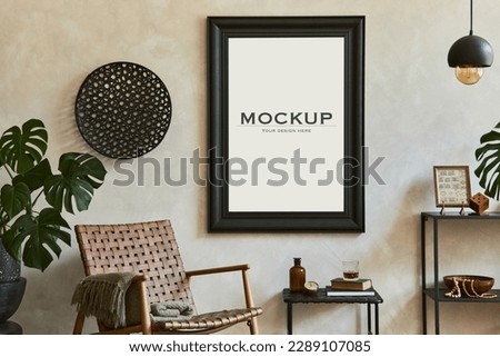 Stylish composition of elegant masculine living room interior with mock up poster frame, brown armchair, industrial geometric shelf and personal accessories. Template. Royalty-Free Stock Photo #2289107085