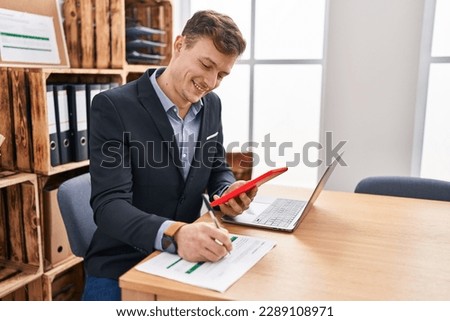Young man business worker using touchpad writing on document at office