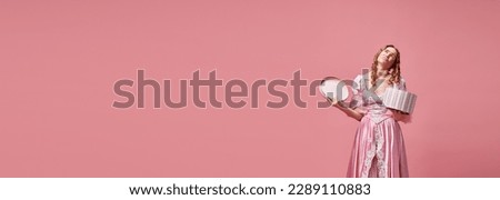 Dislike. Banner with upset, charming, blond princess wearing pink dress and holding gift box with sad face on pink studio background. Concept of medieval, beauty, birthday, human emotions, ad