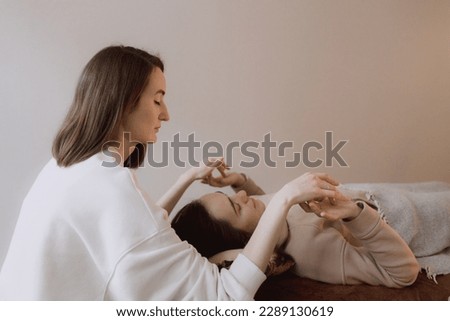 Female energy massage relaxing and care treatment for body and mindfull health gentle woman arms holding head doing access bars. Energetic massage resumes the circulation of energy in body. Royalty-Free Stock Photo #2289130619