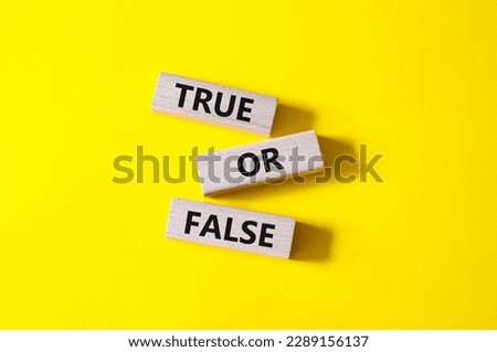 True or false symbol. Wooden blocks with words True or false. Beautiful yellow background. Businessman hand. Business concept and True or false. Copy space.