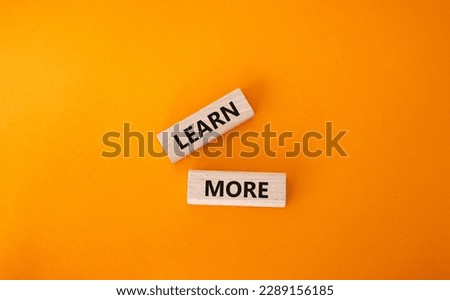Learn more symbol. Concept word Learn more on wooden blocks. Beautiful orange background. Business and Learn more concept. Copy space Royalty-Free Stock Photo #2289156185