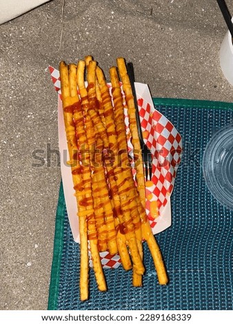 Photo of delicious fries with sauce on the mat