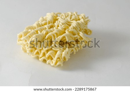 Uncooked instant noodles cut in half isolated on a white background.