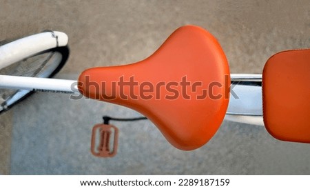 Directly above, top view vibrant brown leather color of bicycle saddle, bicycle seat, selective focus, blurred background, bokeh, vintage, retro, element Royalty-Free Stock Photo #2289187159