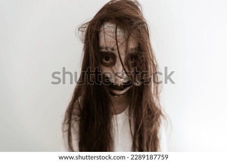 portrait of teenage girl with skull makeup on face.