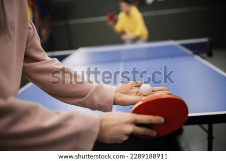 Cropped view of man holding racket and ball while playing table tennis in gaming club Royalty-Free Stock Photo #2289188911