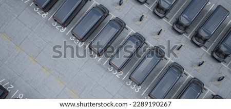 Overhead high angle drone shot of fleet modern electric EV delivery vans standing in company parking garage near charging stations Royalty-Free Stock Photo #2289190267