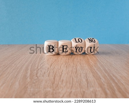 Be you, belong symbol. Turned cubes and changes words 'be you' to 'belong'. Beautiful blue background. Business, belonging and be you, belong concept. Copy space.