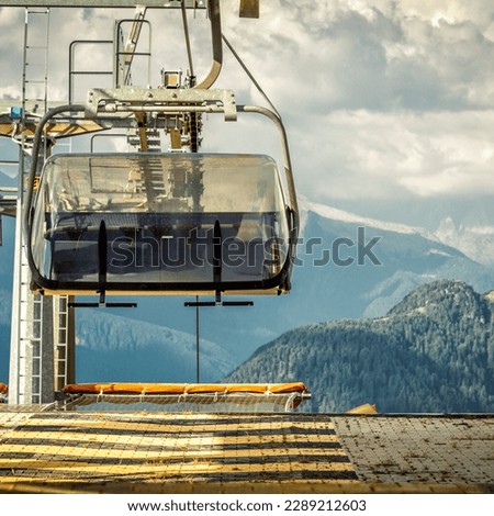 gondola ski lift in mountain ski resort, green forest. Alps. Italy