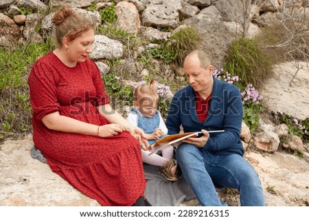 A family is sitting reading a book