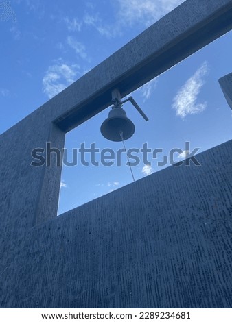 Christian bell on a gray wall. Blonduos church in Iceland. Protestant church. Blönduóskirkja in Icelandic town Blönduós. Sunny day