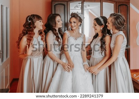 the bride's friend prepares the bride for the wedding day. The bride's friends happily pose with the bride for a photo Royalty-Free Stock Photo #2289241379