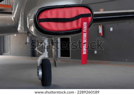 Remove before flight safety warning ribbon on the engine air intake cover of a plane. Royalty-Free Stock Photo #2289260189