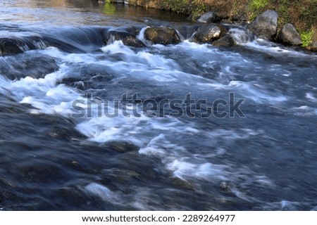 Water stream with low shutter speed flow from left to right with small water fall in the picture