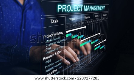 Project manager working on laptop and updating tasks and milestones progress planning with Gantt chart scheduling interface  on virtual screen.Research and development process or business concept.