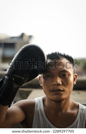 Boxing athlete model posing for the camera wearing black gloves