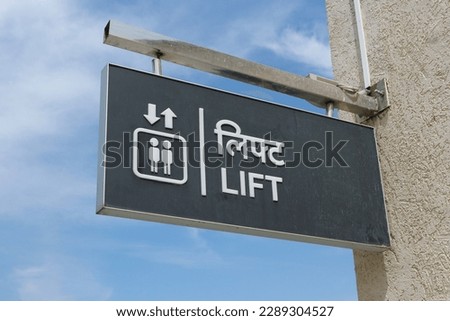 A sign informing about the presence of an elevator for ascent and descent. In English and Hindi it is written "Lift".