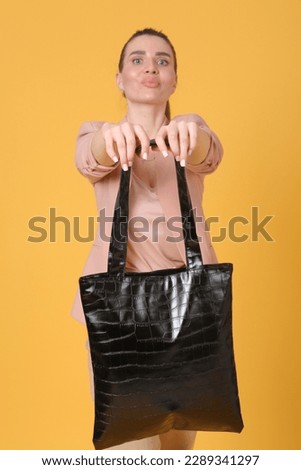 faux crocodile leather black shopper bag close up photo with model hands. High quality photo