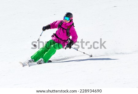 Smiling skier on mountain slope off piste in soft snow on a sunny day