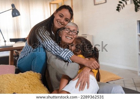 Three female generations family portrait. Cute girl hugging tightly beloved mom and grandma. Royalty-Free Stock Photo #2289362531