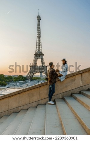 Young couple by Eiffel tower at Sunrise, Paris Eifel tower Sunrise man woman in love, valentine concept in Paris the city of love. Men and women visiting the Eiffel tower.  Royalty-Free Stock Photo #2289363901