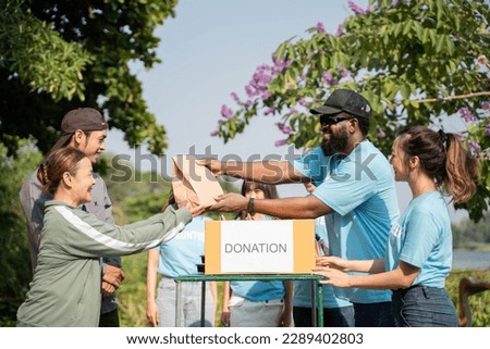 Team of volunteers holding donations boxes in outdoor. Volunteers putting food in donation boxes, social worker making notes charity Royalty-Free Stock Photo #2289402803