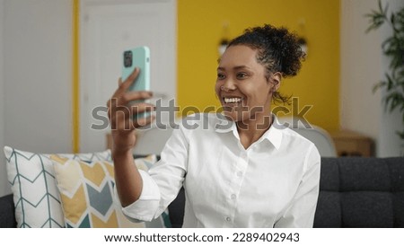 African american woman make selfie by smartphone sitting on sofa at home