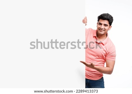 Young indian man showing and pointing of big white board with copy space Royalty-Free Stock Photo #2289413373