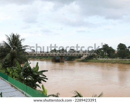 View of the new bridge that passes the Batang Tembesi River in Sarolangun City with a cloudy sky in the background