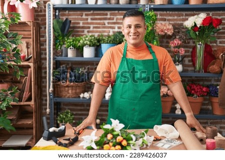 Young latin man florist smiling confident standing at flower shop Royalty-Free Stock Photo #2289426037