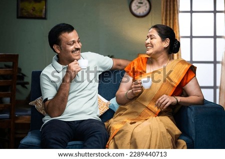 Happy smiling couple having tea or coffee while talking each other at home during morning - concept of family time, relaxation and refreshment Royalty-Free Stock Photo #2289440713
