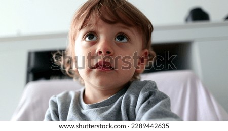 Portrait baby boy hypnotized by screen, child face watching cartoon