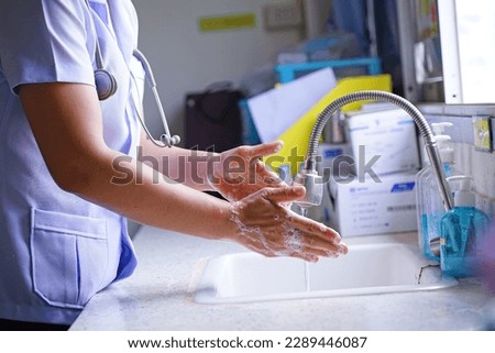 The doctor is cleaning his hands.             