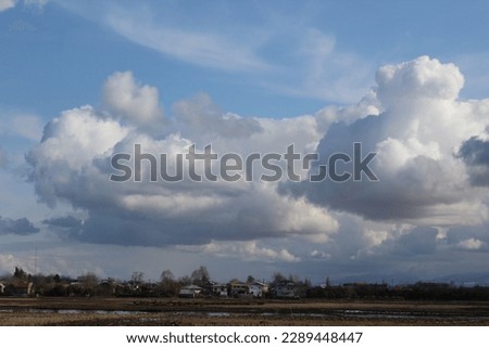 achieve the serene beauty of nature with this scenic landscape featuring a house and billowing white clouds. Ideal for stock photography, perfect for websites, blogs, and social media.
