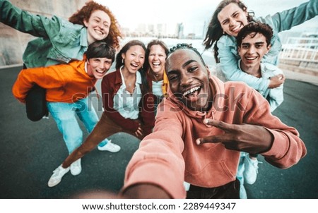 Multicultural group of friends taking selfie picture with smart mobile phone outside - Millenial people walking on city street - Life style concept with guys and girls hanging out together Royalty-Free Stock Photo #2289449347