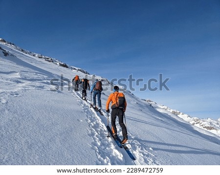 Ski touring group on the way to the summit. Mountaineering with skis in winter on the Gemsfairenstock in Uri. Swiss Alps, Skimo. High quality photo