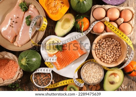 diet food concept- healthy fod selection with protein (chicken fillet,egg and salmon fish), fruit, vegetablea nd meter tape Royalty-Free Stock Photo #2289475639