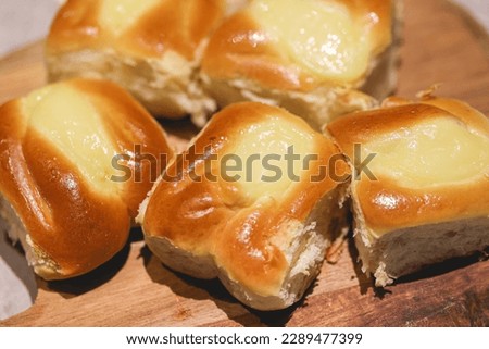 Sweet bread with cream on a wooden board in macro photo. 
 Royalty-Free Stock Photo #2289477399