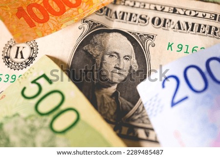 A one dollar bill from the United States with notes of money from Argentina.
 Royalty-Free Stock Photo #2289485487
