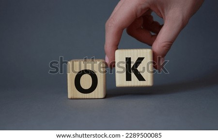 Ok symbol. Concept word Ok on wooden cubes. Businessman hand. Beautiful grey background. Business and Ok concept. Copy space.