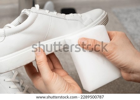 Cleaning white shoes and soles from dust and dirt with a melamine sponge Royalty-Free Stock Photo #2289500787