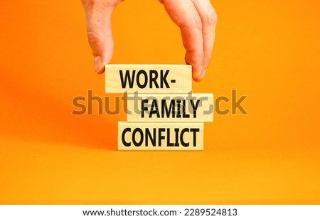 Work-family conflict symbol. Concept words Work-family conflict on wooden block on a beautiful orange table orange background. Businessman hand. Business work-family conflict concept. Copy space.