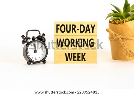 Four-day working week symbol. Concept words Four-day working week on wooden block on a beautiful white table white background. Black alarm clock. Business four-day working week concept. Copy space.