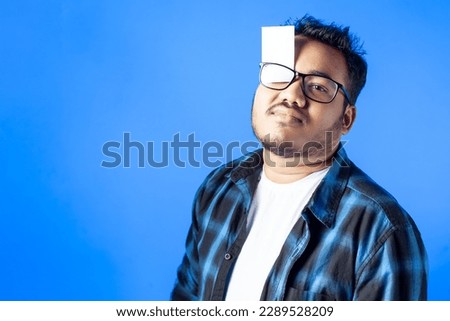 indian man wearing eye glasses showing empty card funny expression