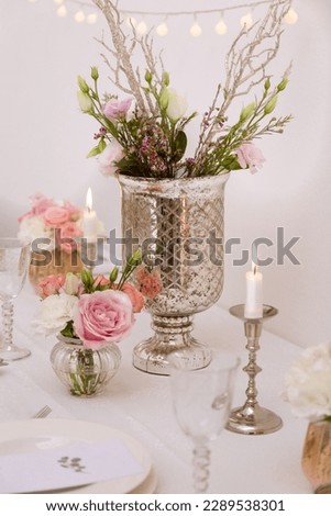 Wedding decor on the table with a vase of flowers and candles on a white background