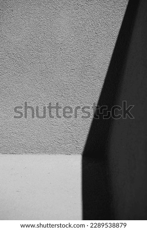shadow on concrete wall creating three dimensional shape black and white contrast shadow play plaster wall simple vertical image room for type architectural or geometric backdrop wallpaper  background