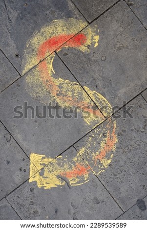 yellow letter S painted on the sidewalk