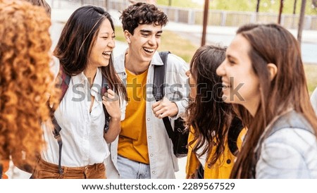 University students talking and laughing together in college campus - Happy teenagers having fun going to school - Friendship concept with guys and girls hanging out on summer day  Royalty-Free Stock Photo #2289567529