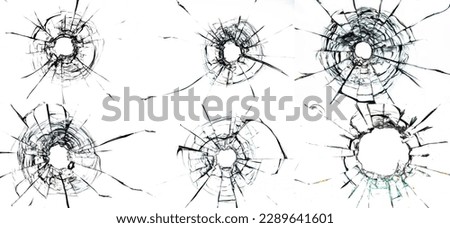 bullet holes and numerous cracks on a plain white glass background, evoking a sense of danger and destruction. The bullet holes are the central focus of the image Royalty-Free Stock Photo #2289641601